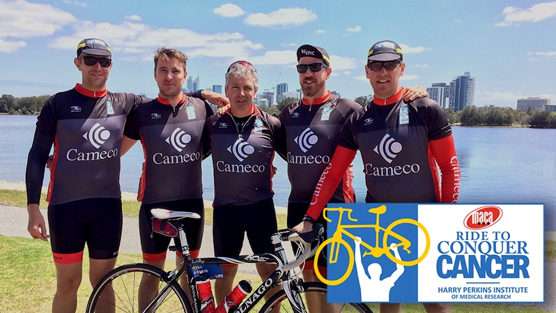 Cameco bikers posing in front of lake